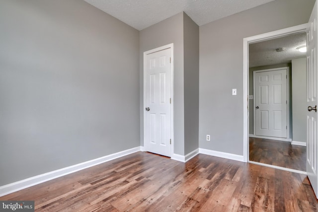 unfurnished bedroom featuring dark hardwood / wood-style floors and a textured ceiling