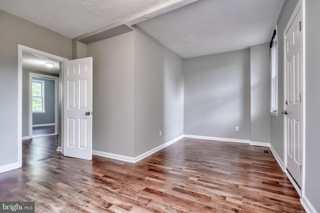 unfurnished room with hardwood / wood-style flooring and a textured ceiling