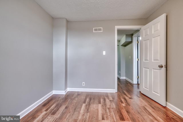 spare room with hardwood / wood-style flooring and a textured ceiling