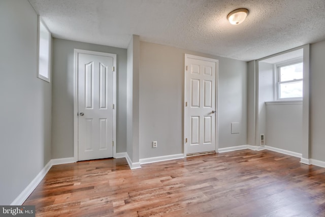 unfurnished bedroom with a textured ceiling and hardwood / wood-style flooring