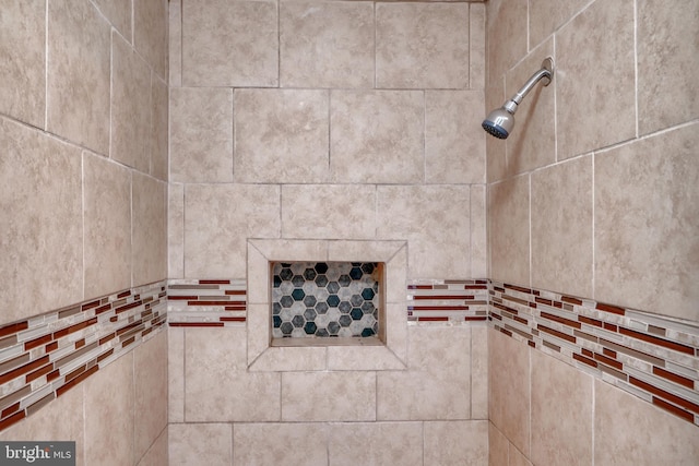 interior details featuring a tile shower