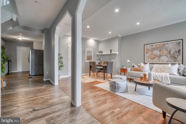 living room with wood-type flooring and a textured ceiling