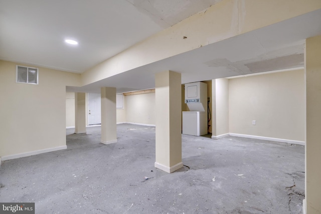 basement with stacked washer / drying machine