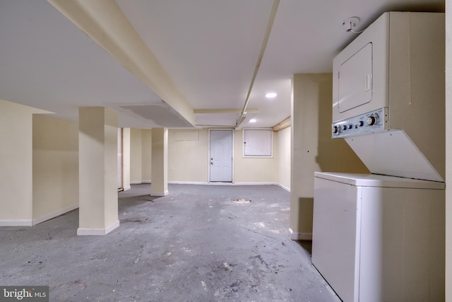 basement featuring stacked washer and clothes dryer