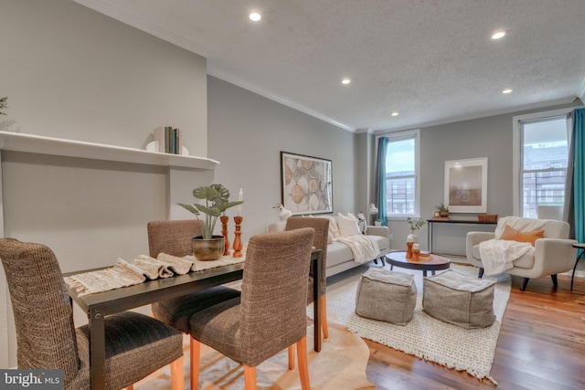 dining space featuring a textured ceiling, hardwood / wood-style flooring, and crown molding