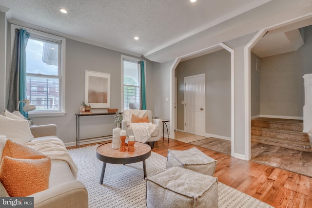 living room with plenty of natural light, light hardwood / wood-style floors, and a textured ceiling