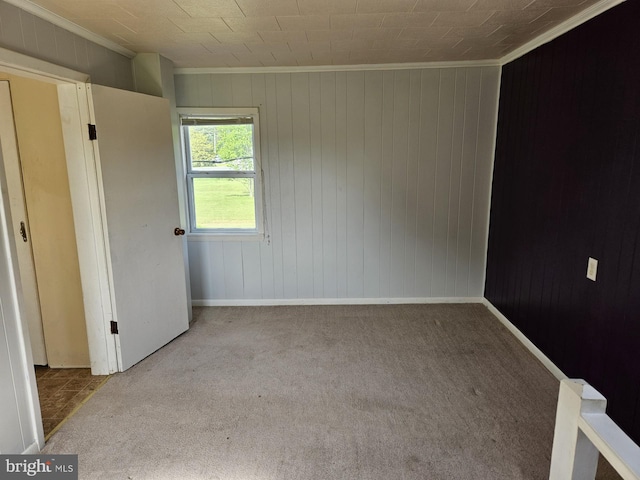 empty room featuring light colored carpet and crown molding