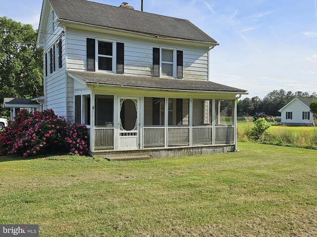 view of front facade featuring a front yard and a sunroom