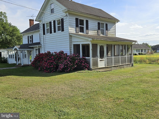 exterior space featuring a sunroom and a yard