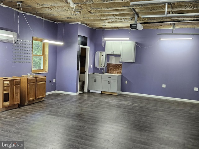 basement with dark hardwood / wood-style floors and an AC wall unit