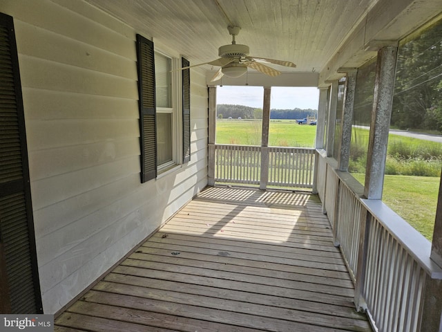 wooden terrace with ceiling fan, a rural view, and a porch