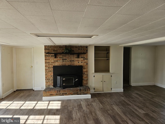 unfurnished living room featuring a wood stove and hardwood / wood-style floors