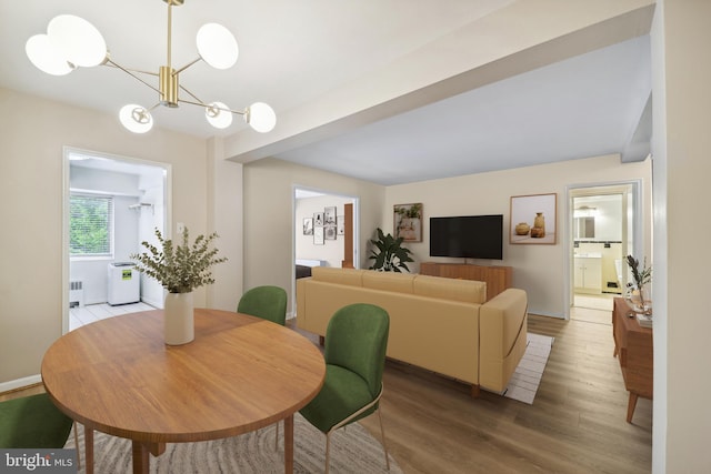 dining space with radiator heating unit, wood-type flooring, and a notable chandelier