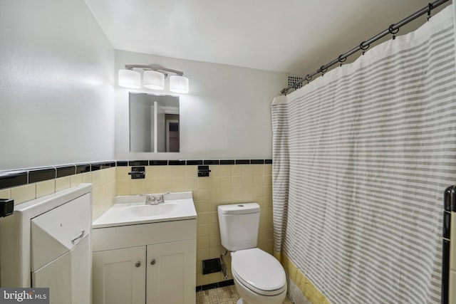 bathroom featuring tile patterned flooring, toilet, vanity, tile walls, and decorative backsplash