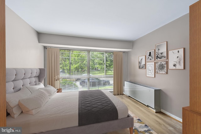 bedroom with light hardwood / wood-style flooring and radiator