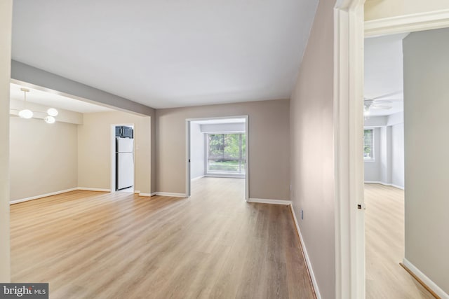 unfurnished room featuring light wood-type flooring and ceiling fan