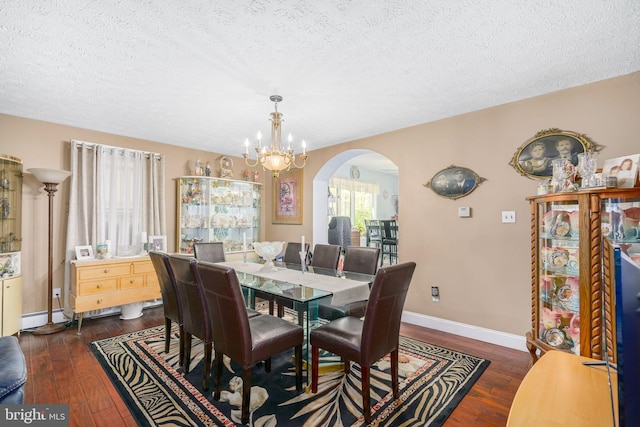 dining room featuring a notable chandelier, dark hardwood / wood-style floors, and a textured ceiling