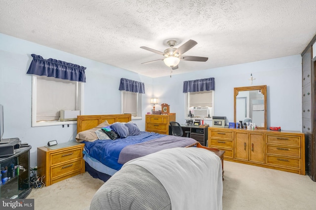 carpeted bedroom featuring ceiling fan and a textured ceiling