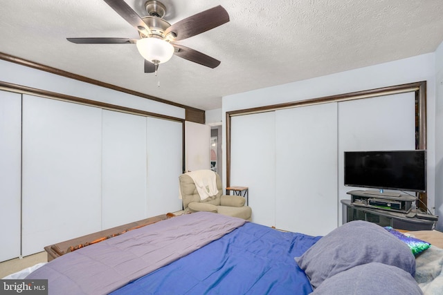 bedroom with ceiling fan and a textured ceiling