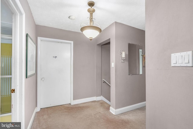 corridor with light carpet and a textured ceiling