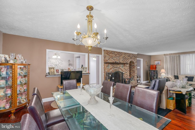 dining space with a fireplace, dark hardwood / wood-style flooring, a textured ceiling, and a notable chandelier