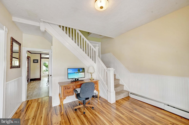 office space featuring a baseboard radiator and light hardwood / wood-style flooring