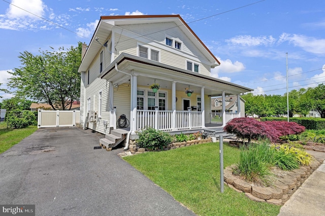 view of front of property with a porch and a front lawn