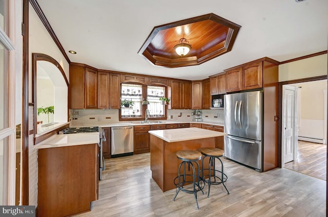 kitchen with a center island, a baseboard radiator, light wood-type flooring, stainless steel appliances, and sink