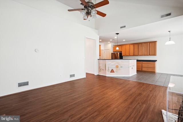 unfurnished living room with hardwood / wood-style floors, ceiling fan, and high vaulted ceiling