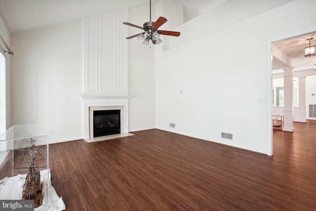 unfurnished living room with ceiling fan, a fireplace, high vaulted ceiling, and dark wood-type flooring