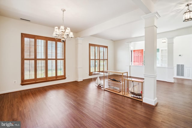 interior space featuring ornate columns, dark hardwood / wood-style floors, and a notable chandelier