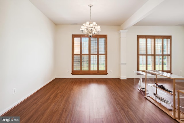 empty room featuring dark hardwood / wood-style flooring and an inviting chandelier