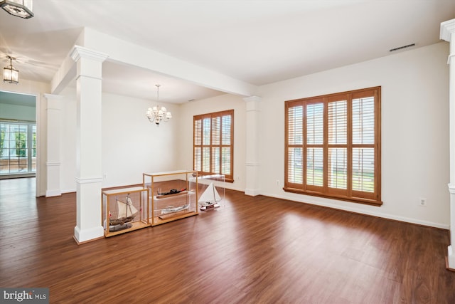 spare room featuring dark hardwood / wood-style floors and an inviting chandelier