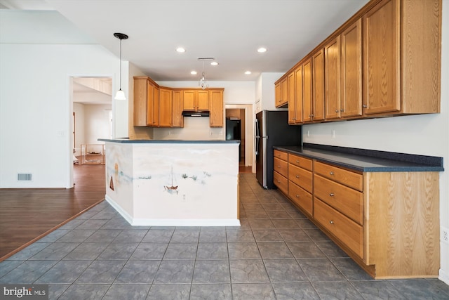 kitchen featuring stainless steel fridge, hanging light fixtures, and dark wood-type flooring