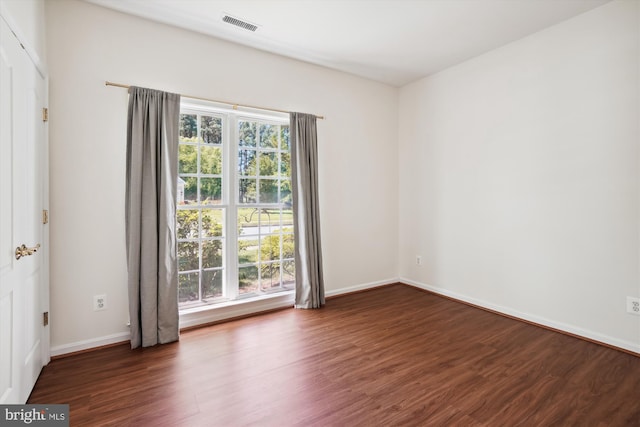 empty room with dark wood-type flooring and a healthy amount of sunlight