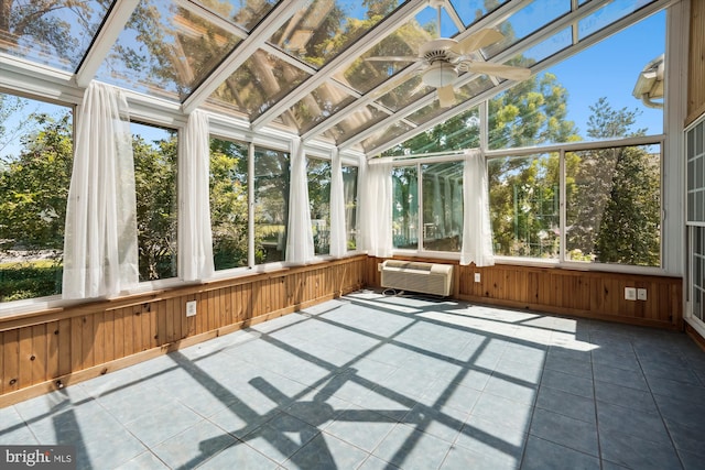 unfurnished sunroom with a wall mounted air conditioner, plenty of natural light, ceiling fan, and vaulted ceiling