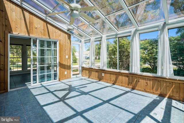 unfurnished sunroom with ceiling fan and vaulted ceiling