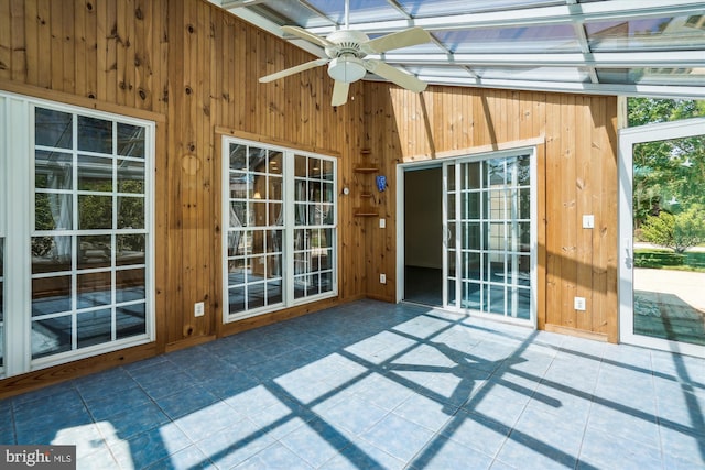 unfurnished sunroom with beamed ceiling and ceiling fan