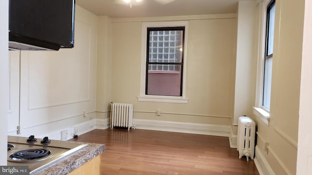 spare room with hardwood / wood-style floors and radiator