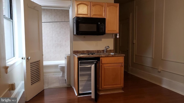 kitchen with sink, beverage cooler, dark hardwood / wood-style flooring, stainless steel gas stovetop, and light brown cabinetry