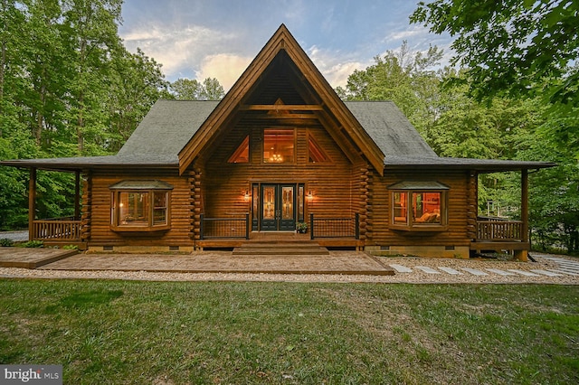 rear view of house with a lawn and french doors