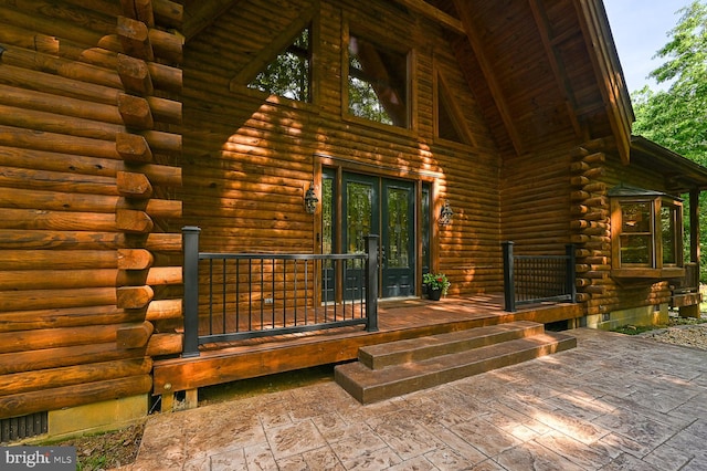 view of exterior entry with covered porch, french doors, and a patio