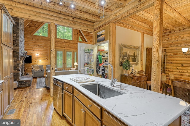 kitchen featuring sink, wooden ceiling, beamed ceiling, light hardwood / wood-style floors, and a kitchen island with sink