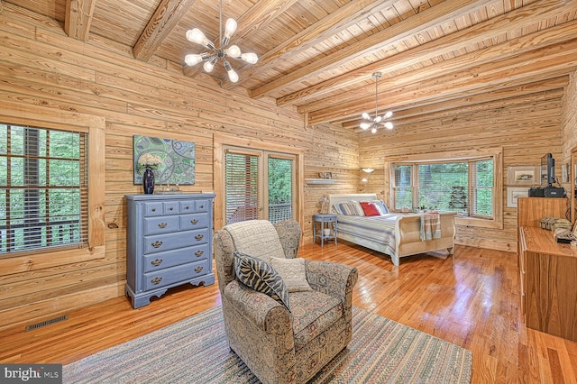 bedroom with beam ceiling, light wood-type flooring, and multiple windows