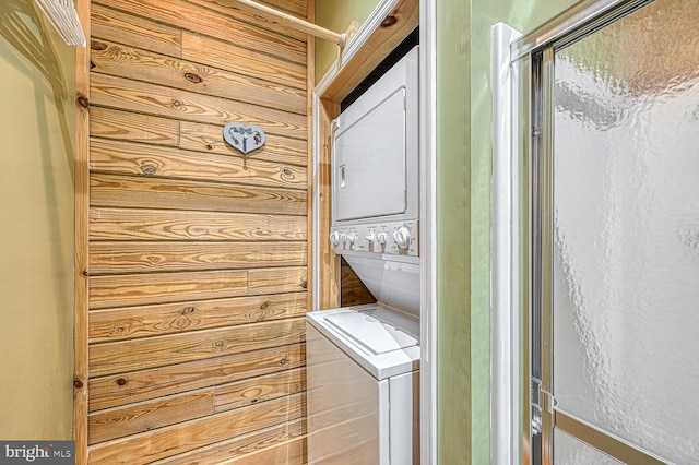 clothes washing area featuring stacked washing maching and dryer