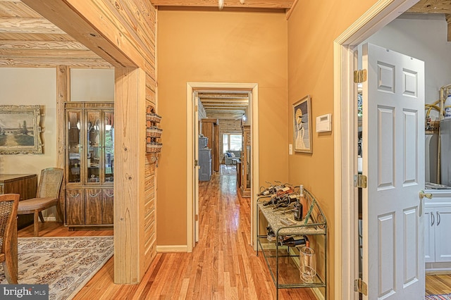 hallway featuring light hardwood / wood-style flooring and beamed ceiling