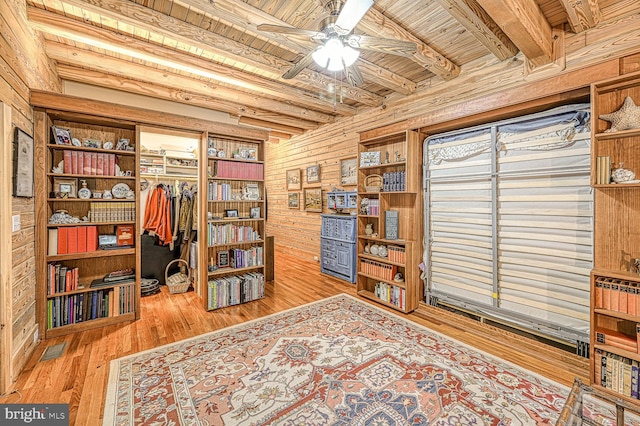 interior space featuring light hardwood / wood-style floors, beam ceiling, wooden ceiling, and wooden walls