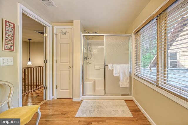 bathroom featuring wood-type flooring and a shower with door