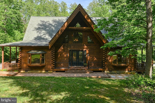 back of property with french doors and a lawn