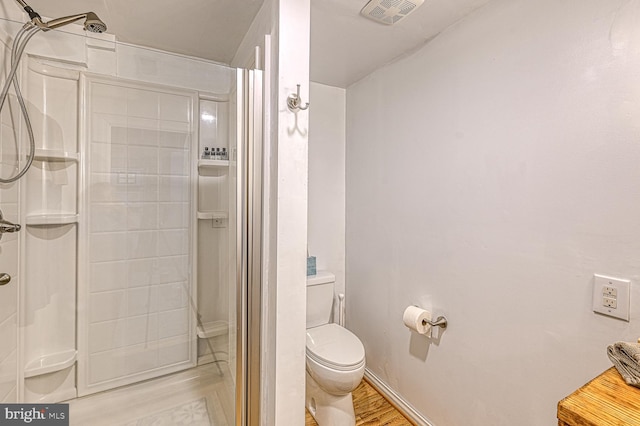 bathroom with wood-type flooring, toilet, and a shower with door